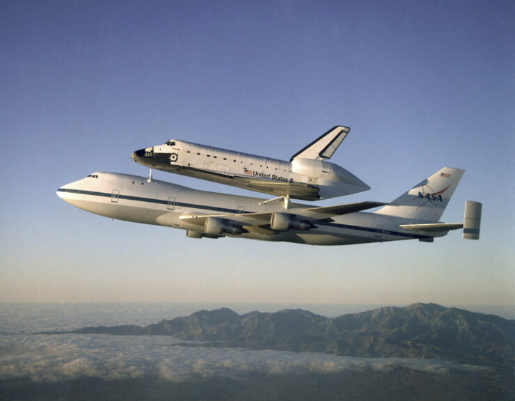 The Space Shuttle orbiter Atlantis, framed by the California mountains, as it rides on the back of one of NASA's Boeing 747