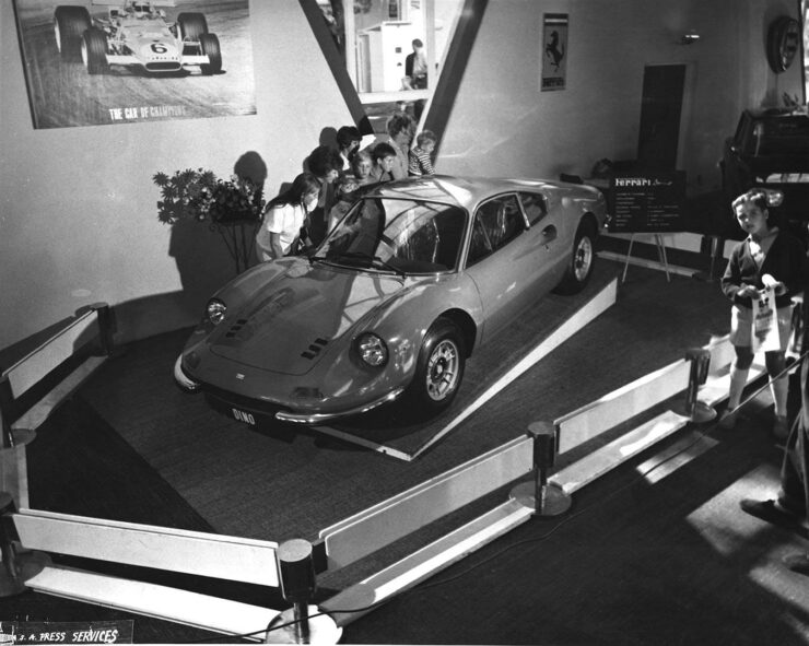 The Ferrari Dino 246 GT at a motor show in 1969 being carefully inspected by some attendees